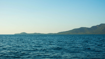 small island with deep blue dark sea view in distance clear sky