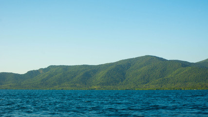 Fototapeta na wymiar big island with deep blue dark sea and clear sky in tropical country