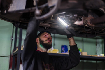 Fototapeta na wymiar Young caucasian man repairing car with professional tools 