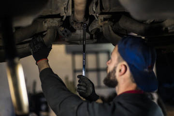 Fototapeta na wymiar Young caucasian man repairing car with professional tools 
