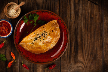 Samsa in plate on wooden table, traditional asian food, top view