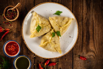 Traditional manti food on plate with sauce, top view