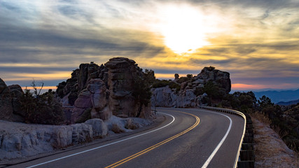 Beautiful scenic mountain roadway on Mount Lemmon in the Catalina Mountains. Curves in the road with a guardrail and cool rock formations called hoodoos. Pima County, Tucson, Arizona, USA.