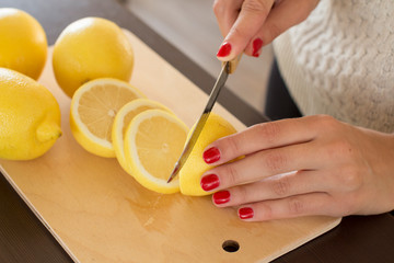 young woman slicing lemons on a cutting board