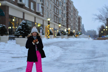 Happy winter time in city of charming girl walking on street enjoying cheerful mood