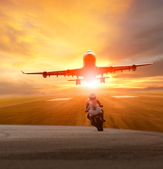 man riding motorcycle on road and plane take off from airport runway background
