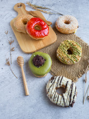 Variety of homemade donuts in wood tray on white background.