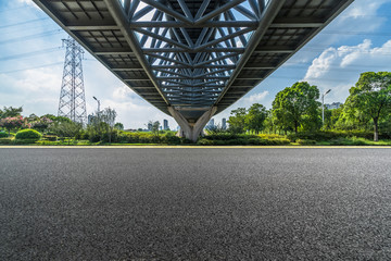 empty asphalt road under the steel bridge