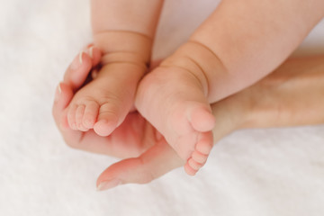 Obraz na płótnie Canvas Baby feet in mamas hands - mother's love concept 