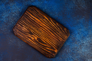 Cutting board on a blue background, top view