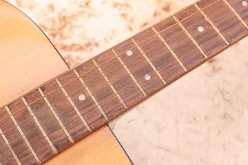 detail of old and dirty acoustic guitar neck with strings, close up. vintage tone for music concept