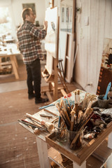 A painter in his studio working on a canvas at sunrise