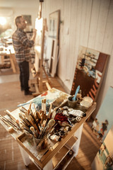A painter in his studio working on a canvas at sunrise