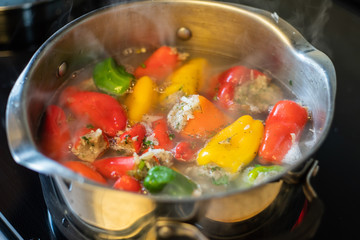 A dish of bell peppers stuffed with mix of rice and meat on the stove in the kitchen.
