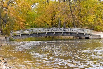 Bridge over river with autumn trees 