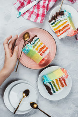 Flat lay of rainbow vegan cake pieces on grey background