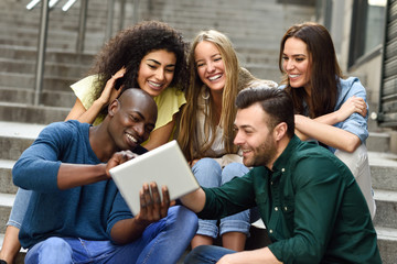 Multi-ethnic group of young people looking at a tablet computer