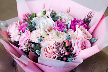 Beautiful bouquet in pink wrapping paper. Roses and other delicate beautiful flowers.