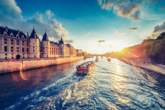 Fototapeta Dramatic sunset over river Seine in Paris, France, with Conciergerie and Pont Neuf. Colourful travel background. Romantic cityscape.