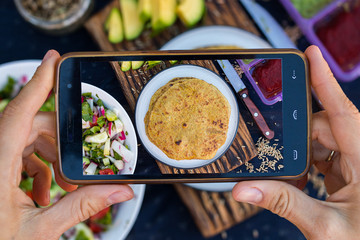 Hands make phone food photography. Smartphone food photo of chapati naan - whole wheat Indian traditional bread. For blogging, social networks. Trend style. Top view.