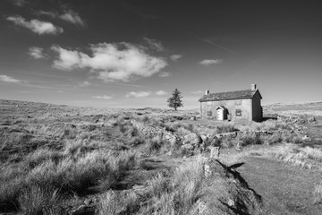 Stunning toned black and white landscape image of Nun's Cross Farm in Dartmoor