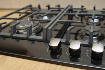 Burners on a black gas cooker in the kitchen.