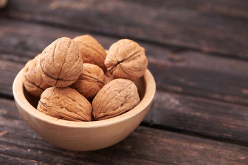 Walnuts on dark vintage table, Walnuts kernels in wooden bowl. Walnut healthy food