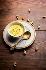 Basundi Or Rabri is an Indian sweet popular in Gujarat and Maharashtra. It is a sweetened condensed milk. Garnished with Dry fruits and Saffron. Served in a bowl over moody background. Selective focus