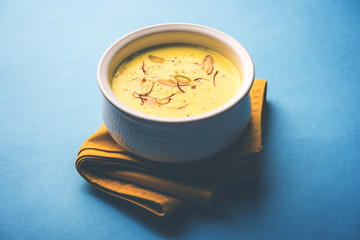 Basundi Or Rabri is an Indian sweet popular in Gujarat and Maharashtra. It is a sweetened condensed milk. Garnished with Dry fruits and Saffron. Served in a bowl over moody background. Selective focus