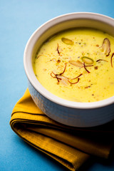 Basundi Or Rabri is an Indian sweet popular in Gujarat and Maharashtra. It is a sweetened condensed milk. Garnished with Dry fruits and Saffron. Served in a bowl over moody background. Selective focus