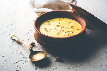 Basundi Or Rabri is an Indian sweet popular in Gujarat and Maharashtra. It is a sweetened condensed milk. Garnished with Dry fruits and Saffron. Served in a bowl over moody background. Selective focus