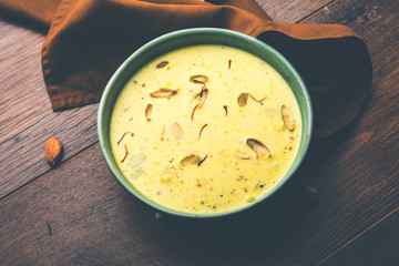 Basundi Or Rabri is an Indian sweet popular in Gujarat and Maharashtra. It is a sweetened condensed milk. Garnished with Dry fruits and Saffron. Served in a bowl over moody background. Selective focus
