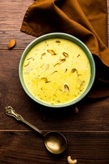 Basundi Or Rabri is an Indian sweet popular in Gujarat and Maharashtra. It is a sweetened condensed milk. Garnished with Dry fruits and Saffron. Served in a bowl over moody background. Selective focus