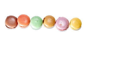 Fresh various colors macaroni cookies allined in line isolated on white background from above perspective