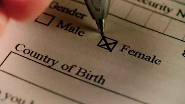 A person checks the female box on a census or immigration form / document