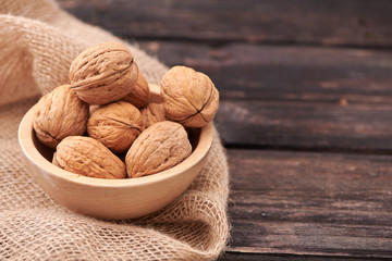 Walnuts on dark vintage table, Walnuts kernels in wooden bowl. Walnut healthy food