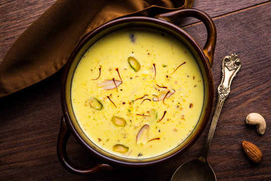 Basundi Or Rabri is an Indian sweet popular in Gujarat and Maharashtra. It is a sweetened condensed milk. Garnished with Dry fruits and Saffron. Served in a bowl over moody background. Selective focus