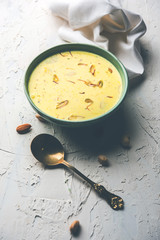 Basundi Or Rabri is an Indian sweet popular in Gujarat and Maharashtra. It is a sweetened condensed milk. Garnished with Dry fruits and Saffron. Served in a bowl over moody background. Selective focus