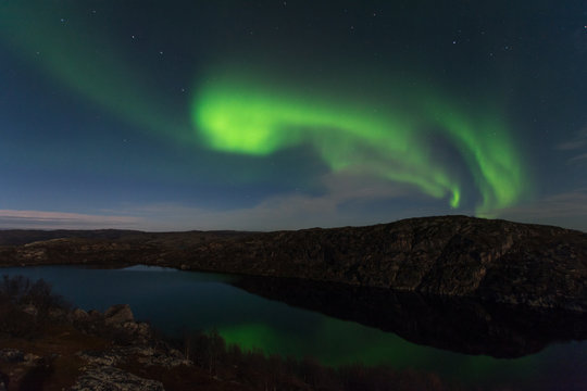 Northern lights, aurora in autumn over the lake.