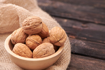 Walnuts on dark vintage table, Walnuts kernels in wooden bowl. Walnut healthy food