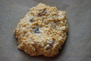 One oat cookie with raisins before bakery. Homemade food. Grey background. Cooking process.