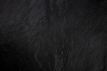 An abstract black slate background, a dark texture with a place for text