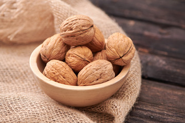 Walnuts on dark vintage table, Walnuts kernels in wooden bowl. Walnut healthy food