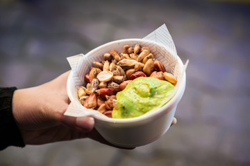 Different kinds of fried Andean corn maize with chilli sauce, a traditional Peruvian snack at a street food market fair festival 