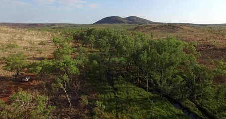 Low level drone flight over four wheel drive vehicle travelling along track in the Kimberley, Australia