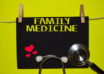 A stethoscope and blackboard with word FAMILY MEDICINE on top of yellow background. Medical, health and education concepts