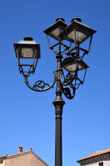 Fototapeta na wymiar street lantern with several lights, decorative and nostalgic street lamp in front of azure sky