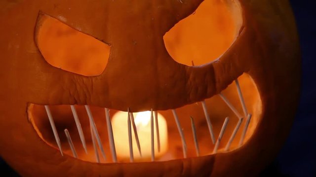 Creepy close up video of a lit Jack-O-Lantern with toothpicks for teeth.  In the middle of the video, the pumpkin shakes a bit as if it is coming to life.  Reminiscent of the headless horseman.