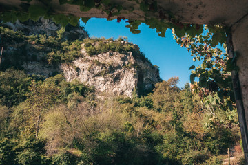 View through the arch on a mountain slope covered with greenery