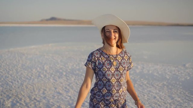 happy smiling girl enjoying a sunset, dancing and laughs on expanse of salt lake